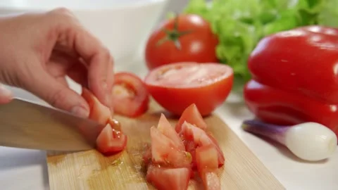 Woman's hands using kitchen knife cutting fresh tomato on wooden cutting board Video stock 157974504
