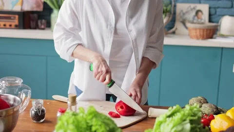Woman's hands using kitchen knife cutting sweet pepper on wooden cutting board Stock Footage 181507011