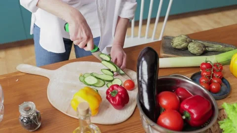 Woman's hands using kitchen knife cutting fresh cucumber on wooden cutting board Stock-Footage 213276143