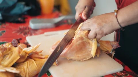 Woman's hands using a knife to cut and prepare a whole raw chicken 動画素材 343555673