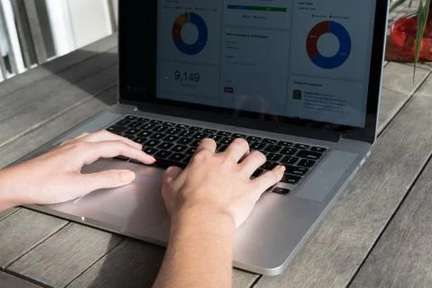 Woman's hands using laptop with analytical graph on desk in the garden Stock Photos