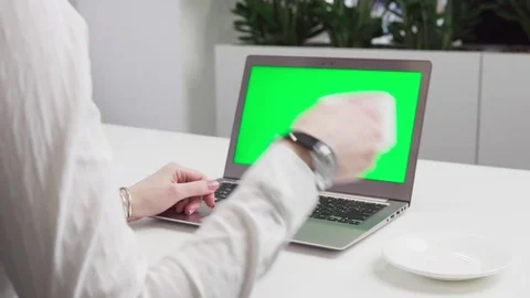 Woman's hands using laptop with green screen on table Stock Footage 86037015