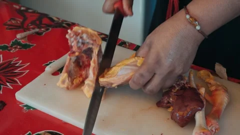 Woman's hands using a large knife to cut a whole raw chicken 動画素材 342978550