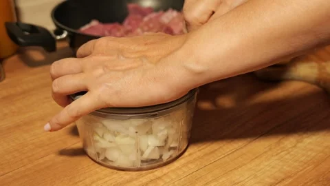 Woman's hands using a manual food chopper to mince onions 動画素材 342758545