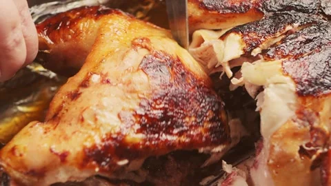A woman's hands, using a sharp knife, cut a whole turkey baked with a spice.. Stock Footage 329502805