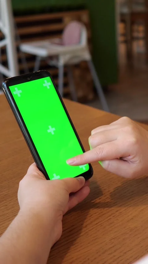 Woman's hands using a smartphone with a green screen, chroma key for app Stock Footage 345406480
