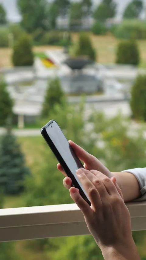 Womans hands using a smartphone outdoors, scrolling and browsing social media or Stock Footage 342908912