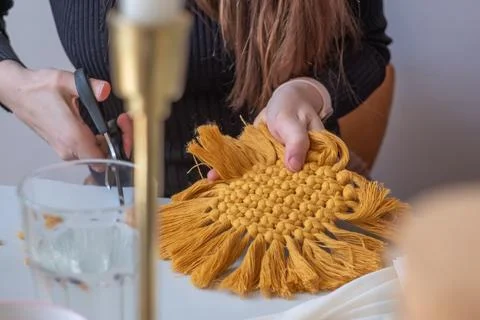 Woman's hands weave yellow macrame decor on table. Handicrafts. Copy space Stock Photos