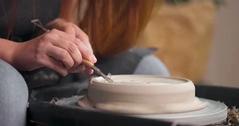 Woman's hands which shaping workpiece with a tool in a pottery studio. Clay Stock Footage 164689692