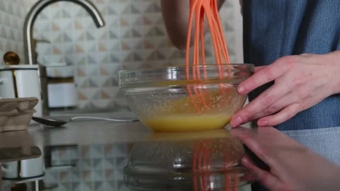 Woman's hands whipping eggs in a glass bowl. Vídeo Stock 273530853