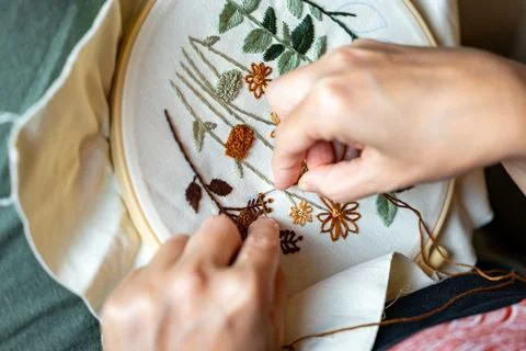 Woman's hands working on embroidery with thread and needle Stock Photos