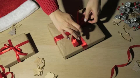 Woman's hands wrapping and rotating Christmas gifts at home, view from above Stock Footage 166057760