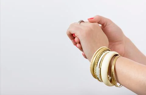 Woman's hands with yellow bracelets Stock Photos