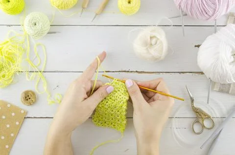 Woman's knitting workspace and tools on a white wooden table. Needlework with Stock Photos