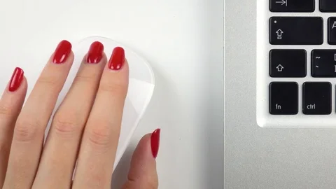 Woman's left hand with red manicure using a wireless computer mouse. Top view 库存影片 84757511