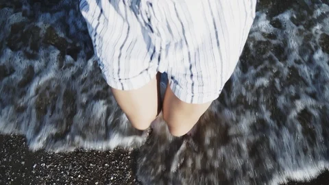 Woman's legs makes small jumps in the sea water at sunset. Close-up, female l 스톡 동영상 115029977