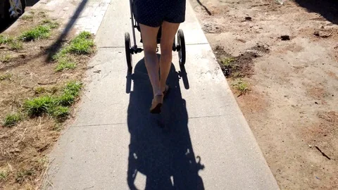 A woman's legs pushing pram stroller. Stock Footage 99615057