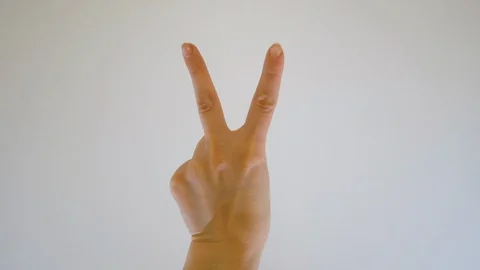 A womans makes the victory hand gesture Stock Footage 129534025