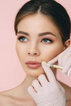 Woman's plumper lips, getting bigger lips. prick of a syringe for the lips... Stock Photos