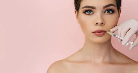 Woman's plumper lips, getting bigger lips. prick of a syringe for the lips... Stock Photos