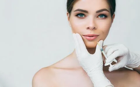 Woman's plumper lips, getting bigger lips. prick of a syringe for the lips... Stock Photos