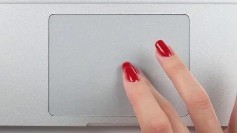 Woman's right hand with red manicure using and clicking a trackpad. Top view 库存影片 84756987