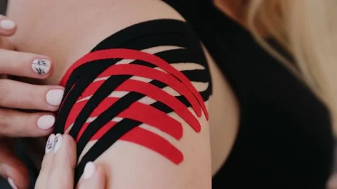 Woman's shoulder joint with applied kinesio tape. Kinesiotherapy Stock Footage 131152313