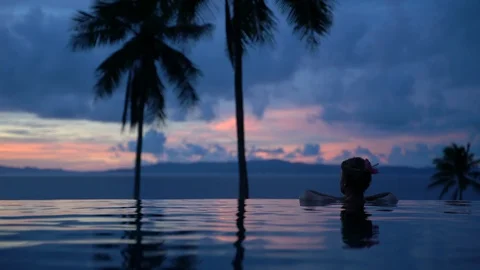 Woman's silhouette in infinity pool 動画素材 127806546