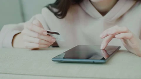 Woman's tapping tablet holding credit card. Online payment and online purchases. Stock Footage 149142247