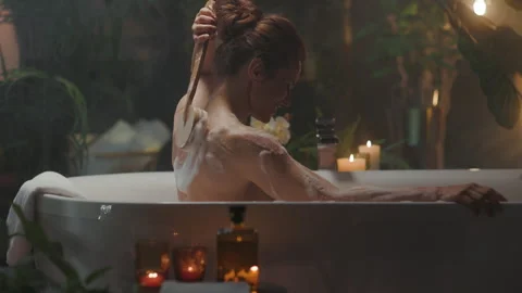 Woman's Tranquil Bathing Ritual with Long Brush Stock Footage 320030981