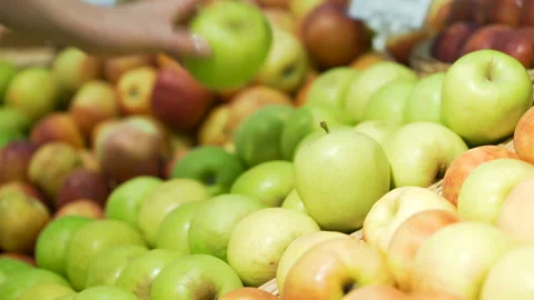 Woman's white hands take few colorful green apple one by one in marketplace and Video stock 199491773