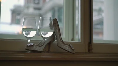 Woman's white shoes and two glasses of champagne Stock Footage