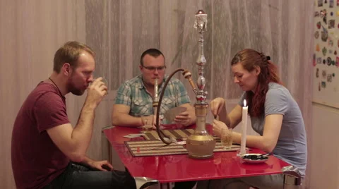 Women and men smoking shisha and playing cards Stock Footage 59583145