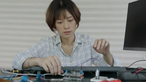 Women are uploading programs into the microcontrollers to learn about and experi Stock Footage 334046308