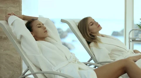 Women in bathrobes lying on the loungers Stock Footage 59105453