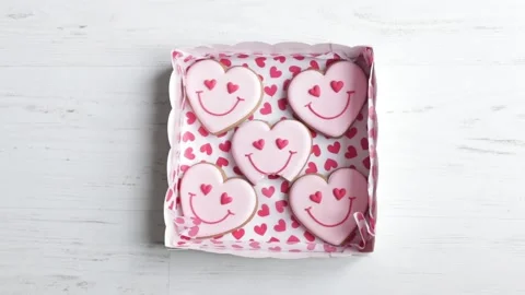 Women bite cookie, hands put in box gingerbread in shape of smiling hearts Stock Footage 232959523