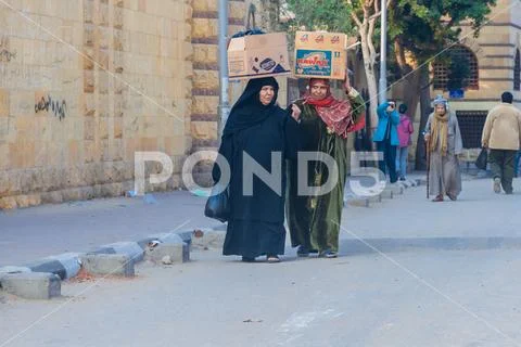 Women carry on their heads filled cartons Stock Photos