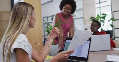 Women collaborating in office with data processing animation over laptop screen Stock Footage 327642069