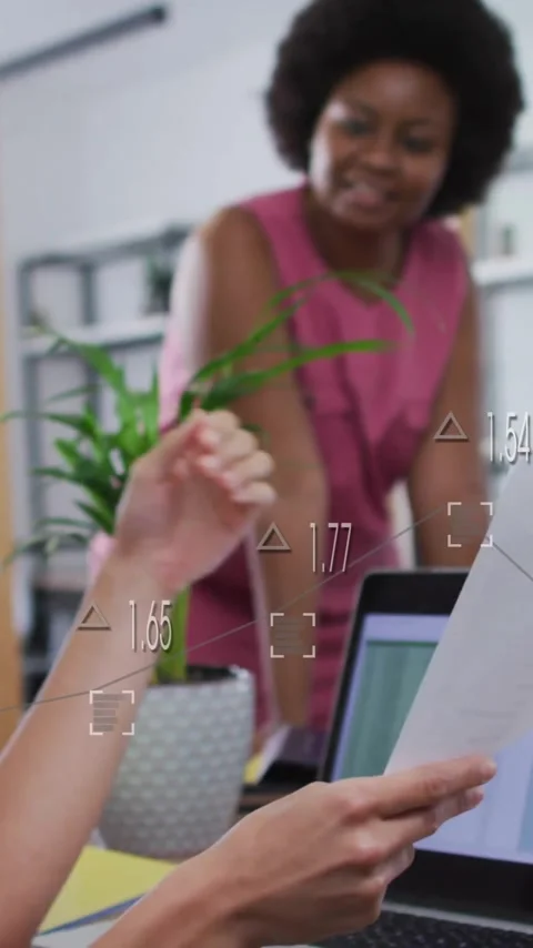 Women collaborating in office with data processing animation over laptop screen Stock Footage 344370336