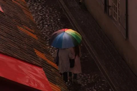 Women with colorful rainbow umbrella walking on the old street in Tallinn Est Stock Photos