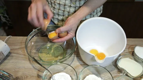 Women cracking eggs and separating yolk from whites Stock Footage 57464171