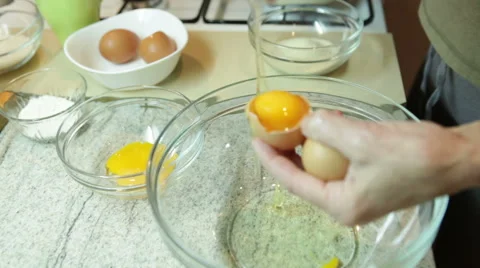 Women cracking eggs and separating yolk from whites Stock Footage 58150144