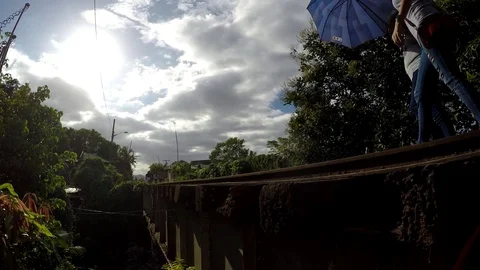 Women crossing old railway road bridge on foot Stock Footage