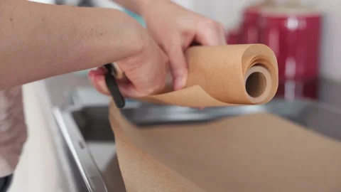 Women cutting baking paper with scissors close up starting bakery process Stock Footage 146797331