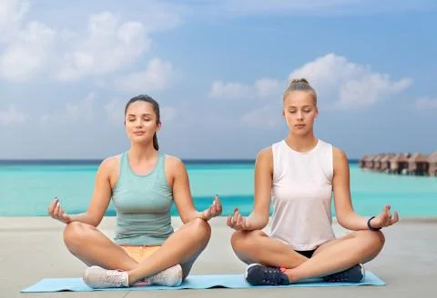 Women doing yoga and meditating in lotus pose Stock Photos
