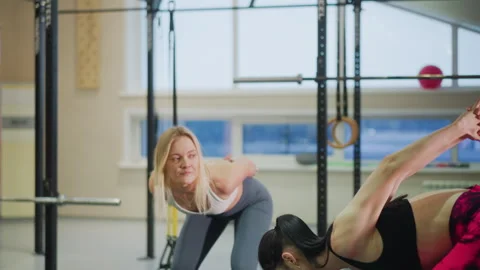 Women exercise help, Bright gym environment with women and trainer practicing Stock Footage 346398130
