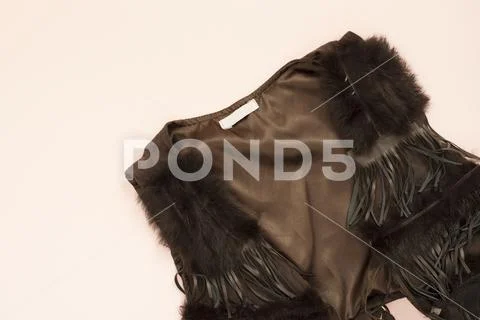 Women fashion brown faux suede fringe vest. Pastel punchy pink background. Conce Stock Photos
