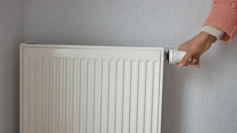 Women hand changing temperature on heating radiator Video stock 232969526