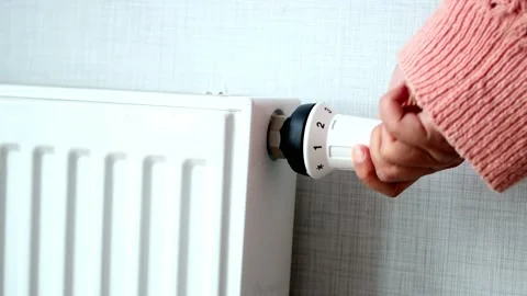 Women hand changing temperature on heating radiator Video stock 233535547
