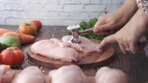 Women hand processing raw chicken breast on a chopping board Stock Footage 195201347